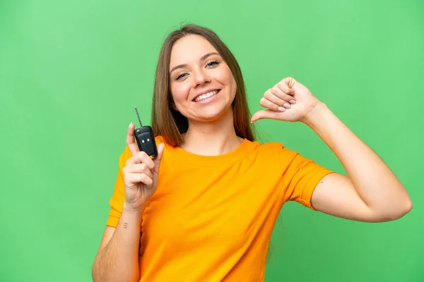 stock image Young woman holding car keys over isolated chroma key background proud and self-satisfied