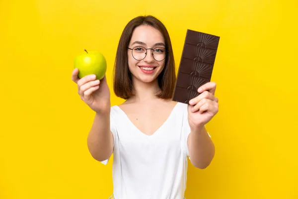 Young Ukrainian Woman Isolated Yellow Background Taking Chocolate Tablet One — Fotografia de Stock