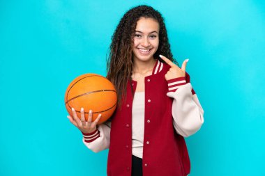 Arap basketbolcu kadın, mavi arka planda izole edilmiş bir şekilde baş parmak işareti yapıyor.