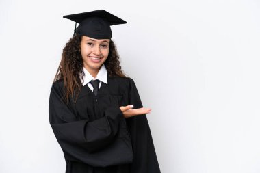 Genç üniversite mezunu Arap bir kadın beyaz arka planda izole edilmiş bir şekilde bir fikir sunarken gülümseyerek