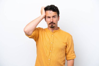 Bıyıklı genç adam, beyaz arka planda, hayal kırıklığı ifadesi ile izole edilmiş ve anlamamış.