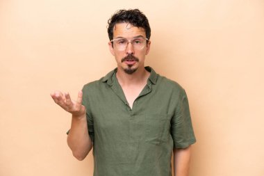 Beyazların arka planında izole edilmiş genç beyaz adam şüpheli hareketler yapıyor.