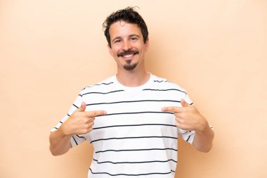 Beyazlı genç bir adam bej arka planda soyutlanmış gururlu ve kendinden memnun