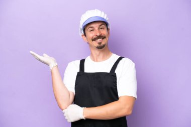 Mor arka planda izole edilmiş önlük giyen balıkçı adam daveti için elini yana uzatıyor.