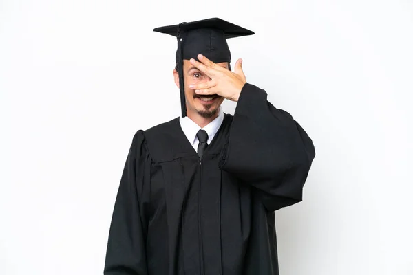 年轻的大学毕业生被白色背景隔离 双手捂住眼睛 面带微笑 — 图库照片