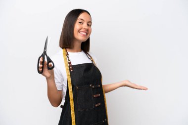 Young seamstress woman isolated on white background extending hands to the side for inviting to come