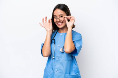 Young surgeon doctor woman isolated on white background with glasses and surprised