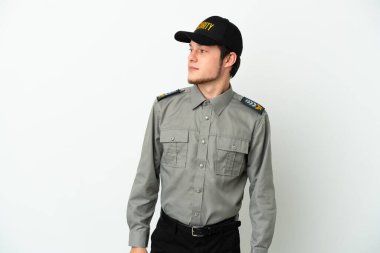 Beyaz arka planda izole edilmiş genç Rus güvenlik görevlisi yan tarafa bakıyor.