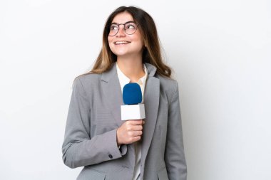 Beyaz arka planda izole edilmiş beyaz televizyon sunucusu genç kadın yukarı bakarken bir fikir düşünüyor.