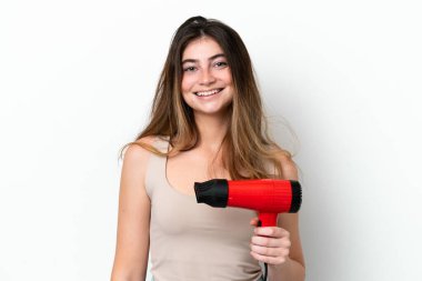 Beyaz arka planda izole edilmiş saç kurutma makinesi tutan beyaz bir kadın. Şaşırmış ve şok olmuş bir yüz ifadesi var.