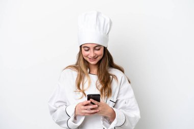 Young caucasian chef woman isolated on white background sending a message with the mobile