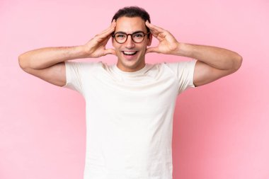 Young caucasian man isolated on pink background with surprise expression