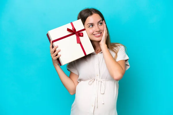 Young Caucasian Woman Isolated Blue Background Pregnant Holding Gift — Stockfoto