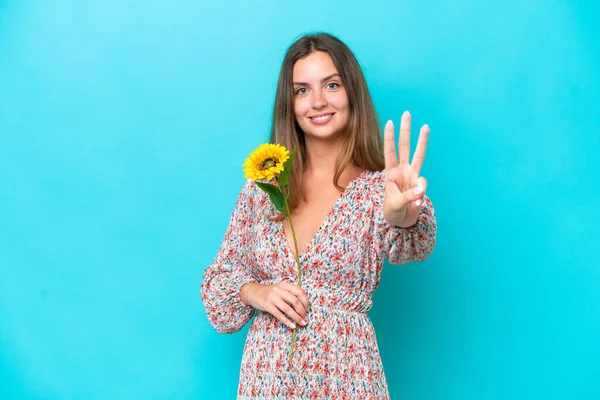 Young Caucasian Woman Holding Sunflower Isolated Blue Background Happy Counting — Stock Photo, Image