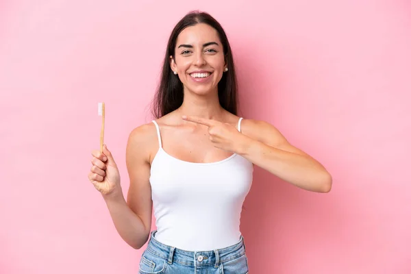 Молода Біла Жінка Чистить Зуби Ізольовано Рожевому Фоні Вказує Нього — стокове фото