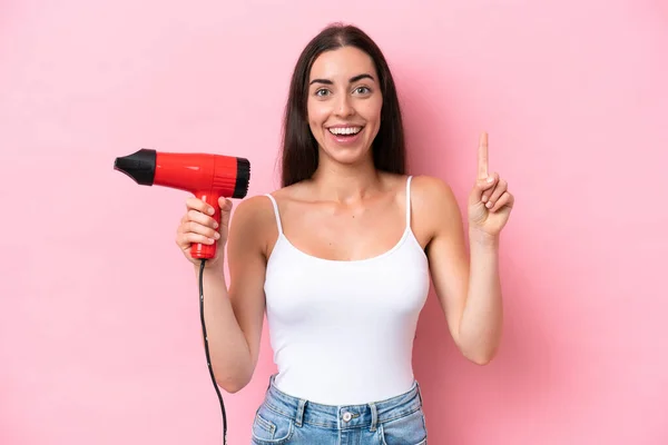 Jonge Blanke Vrouw Met Een Haardroger Geïsoleerd Roze Achtergrond Wijzen — Stockfoto