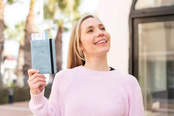 Sarışın Bir Kadın Elinde Pasaportuyla Dışarı Bakıyor Gülümsüyor — Stok fotoğraf