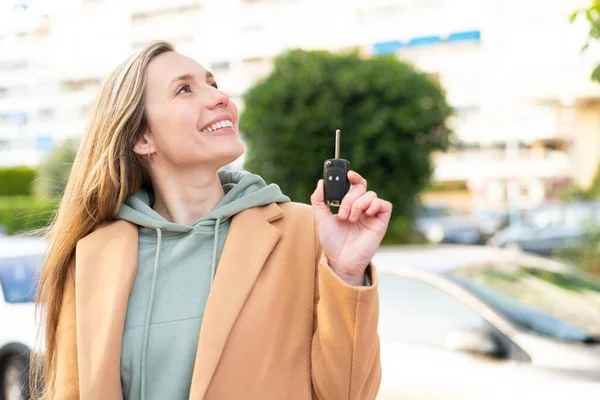 Νεαρή Ξανθιά Γυναίκα Κρατώντας Κλειδιά Του Αυτοκινήτου Εξωτερικούς Χώρους Κοιτάζοντας — Φωτογραφία Αρχείου