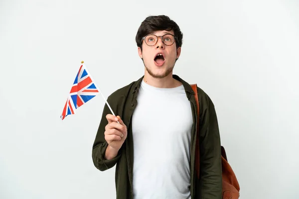 年轻的俄罗斯男子举着一面英国国旗 背景是白色的 他抬起头 面带惊讶的表情 — 图库照片