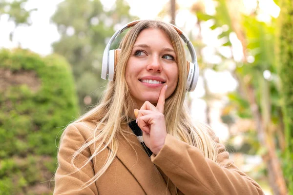 Молодая Красивая Блондинка Слушает Музыку Наушниках Открытом Воздухе Думая Идее — стоковое фото
