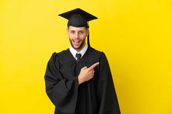 Genç Üniversite Mezunu Sarı Arka Planda Izole Edilmiş Şaşırmış Işaret — Stok fotoğraf