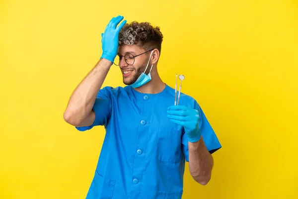 Dentysta Kaukaski Mężczyzna Trzymając Narzędzia Izolowane Żółtym Tle Coś Sobie — Zdjęcie stockowe