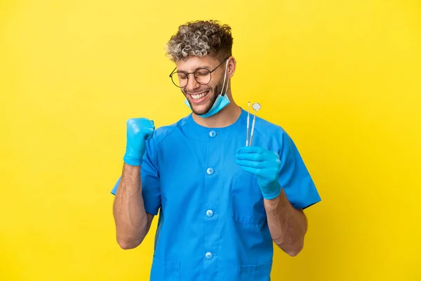 Dentista Caucasiano Homem Segurando Ferramentas Isoladas Fundo Amarelo Comemorando Uma — Fotografia de Stock