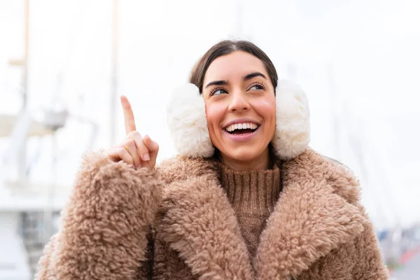 年轻女子在户外穿着冬衣 想在举起一只手指头的同时实现这个解决方法 — 图库照片