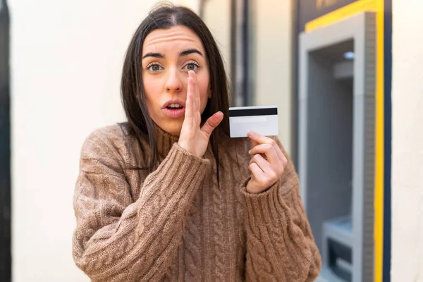 Νεαρή Γυναίκα Που Κρατάει Μια Πιστωτική Κάρτα Εξωτερικούς Χώρους Ψιθυρίζει — Φωτογραφία Αρχείου