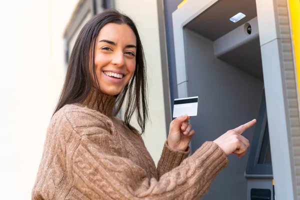 stock image Young woman holding a credit card at outdoors