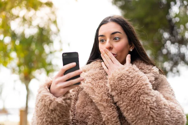 Ung Kvinna Som Använder Mobiltelefon Utomhus Med Överraskning Och Chockad — Stockfoto
