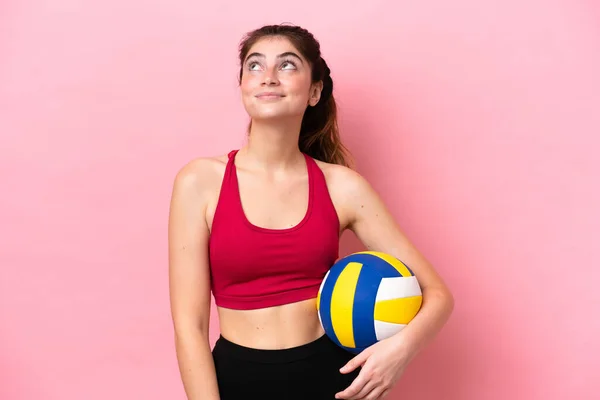 Молодая Белая Женщина Играющая Волейбол Розовом Фоне Думает Идее Глядя — стоковое фото