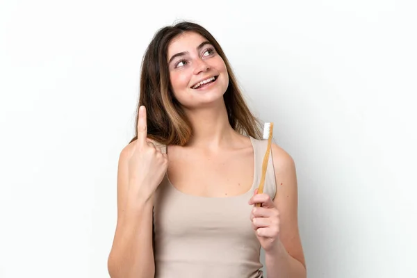 指を持ち上げながら溶液を実現しようとする白い背景に隔離された歯をブラッシング若い白人女性 — ストック写真