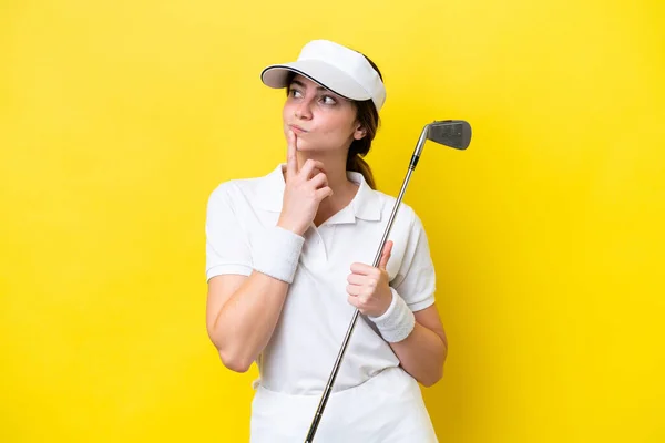 Jong Kaukasisch Vrouw Spelen Golf Geïsoleerd Gele Achtergrond Met Twijfels — Stockfoto