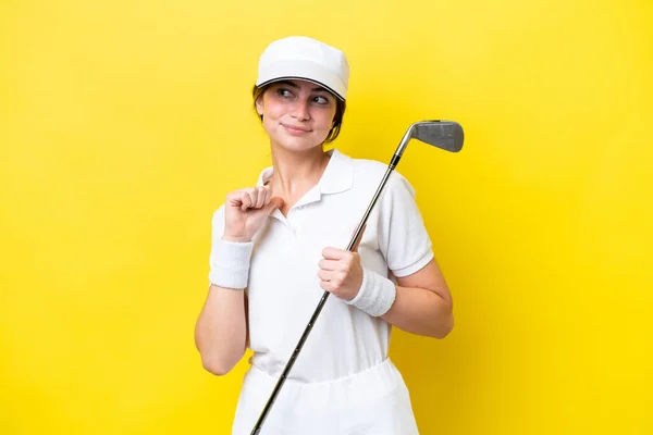 Joven Mujer Caucásica Jugando Golf Aislado Sobre Fondo Amarillo Orgulloso —  Fotos de Stock
