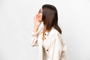 Young Russian woman over isolated white background shouting with mouth wide open to the side