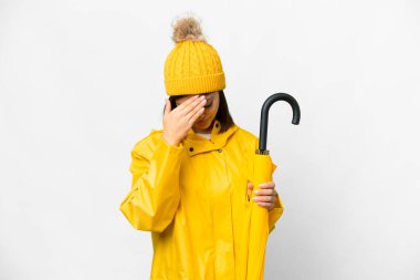 Yağmura dayanıklı paltosu ve şemsiyesi olan genç bir Rus kadın.