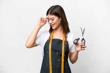 Seamstress woman over isolated white background laughing