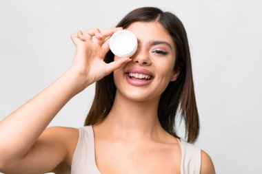 Young Russian woman over isolated white background with moisturizer and happiness