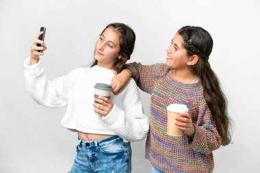 Arkadaşlar izole edilmiş beyaz arka planda cep telefonuyla selfie çekiyorlar.