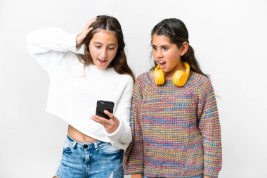 Arkadaşlar izole edilmiş beyaz arkaplan üzerinde kızlar cep telefonuyla bir mesaj okuyor