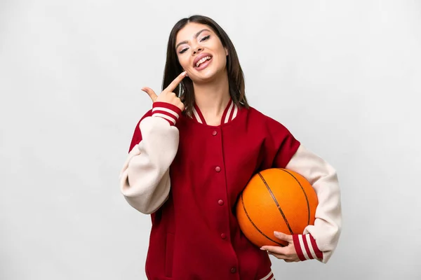 年轻的俄罗斯女子在与世隔绝的白色背景下打篮球 伸出大拇指示意 — 图库照片