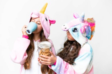 Friends girls with unicorn pajamas over isolated white background
