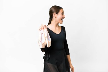 Beyaz arka planda bale yapan genç bir kadın yan yana gülerek gülüyor.