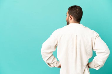 Sarışın yakışıklı adam, mavi arka planda, arka tarafta ve yan tarafta.