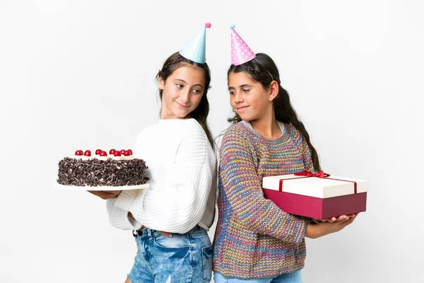 Przyjaciele Dziewczyny Trzyma Prezent Tort Urodzinowy Odizolowanym Białym Tle Patrząc — Zdjęcie stockowe