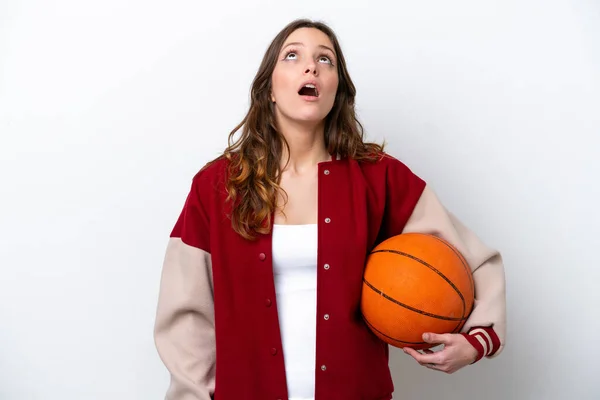Молодая Белая Женщина Играющая Баскетбол Белом Фоне Смотрит Вверх Удивленным — стоковое фото