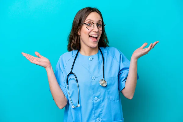 Junge Chirurg Ärztin Isoliert Auf Blauem Hintergrund Mit Schockiertem Gesichtsausdruck — Stockfoto