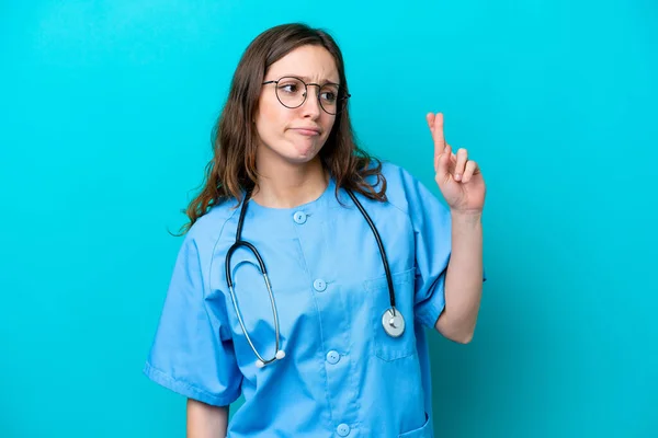 Junge Chirurgin Ärztin Isoliert Auf Blauem Hintergrund Mit Daumendrücken Und — Stockfoto