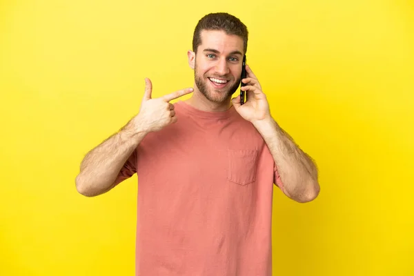 Przystojny Blondynka Człowiek Pomocą Telefon Komórkowy Odosobnione Tło Dając Kciuki — Zdjęcie stockowe